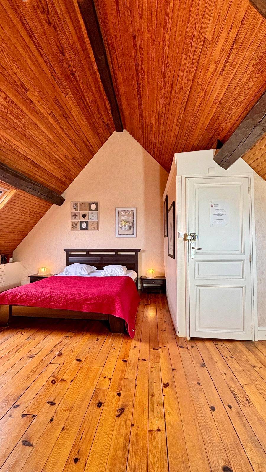 Chambre sous les combles avec charpente apparente