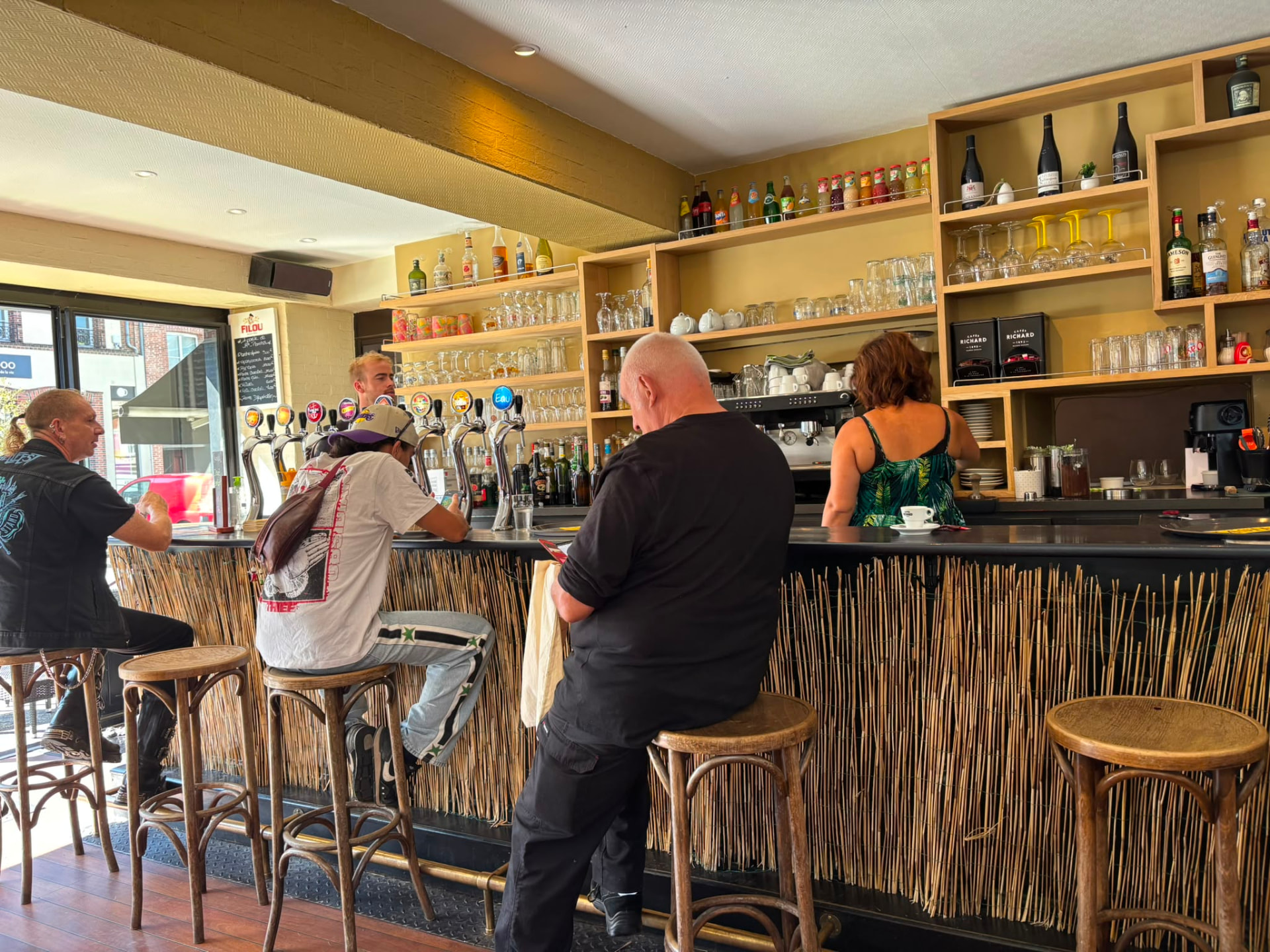 Clients installés au comptoir du bar en journée