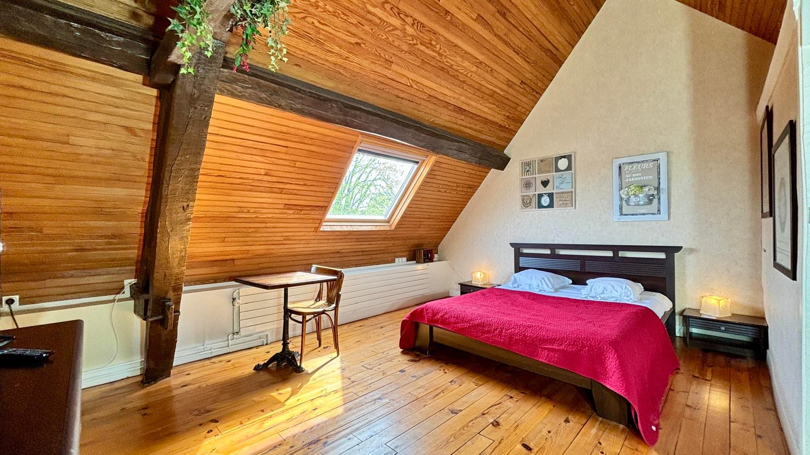 Chambre mansardée aux boiseries et parquet, lit double